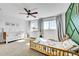 Cozy bedroom with a ceiling fan, natural light, and a view of the changing table, crib, and toddler bed at 12408 W 83Rd Ave, Arvada, CO 80005