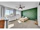 Charming toddler bedroom featuring a green accent wall, a toddler bed, a dresser, and a window with natural light at 12408 W 83Rd Ave, Arvada, CO 80005