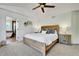 Comfortable bedroom with neutral carpet, a ceiling fan, and view to a bathroom with modern tub and walk-in shower at 12408 W 83Rd Ave, Arvada, CO 80005