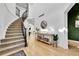 Grand foyer featuring a curved staircase, high ceilings, wood floors, and a stylish console table with decor at 12408 W 83Rd Ave, Arvada, CO 80005