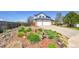Artistic front yard with interesting plants, mulch, decorative rocks, rock border, and a view of the home's garage at 12408 W 83Rd Ave, Arvada, CO 80005