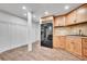 Modern kitchen with wooden cabinets, a black refrigerator, and stylish backsplash at 12408 W 83Rd Ave, Arvada, CO 80005