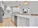 Kitchen featuring white cabinets, stainless appliances, gold hardware, and a center island at 12408 W 83Rd Ave, Arvada, CO 80005