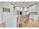 Kitchen featuring white cabinets, stainless appliances, a white backsplash, and counter seating at 12408 W 83Rd Ave, Arvada, CO 80005