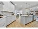 Spacious open kitchen with white cabinets, stainless steel appliances, large island, and hardwood floors at 12408 W 83Rd Ave, Arvada, CO 80005