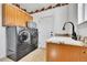 Convenient laundry room featuring a stacked washer and dryer and a utility sink with ample cabinet storage at 12408 W 83Rd Ave, Arvada, CO 80005