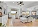 Spacious living room with hardwood floors, a ceiling fan, and lots of natural light with a dining area in the background at 12408 W 83Rd Ave, Arvada, CO 80005