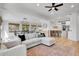 Living room featuring open floor plan, wood floors, and access to the dining room at 12408 W 83Rd Ave, Arvada, CO 80005