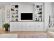 Bright living room with custom built-in shelving, cabinets, and entertainment center for a modern and organized space at 12408 W 83Rd Ave, Arvada, CO 80005