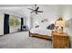 Large primary bedroom with vaulted ceilings, a ceiling fan, a window with natural light, and a view of the ensuite bath at 12408 W 83Rd Ave, Arvada, CO 80005