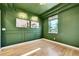 Stylish room with green walls, hardwood floors, framed art, decorative trim, and a window at 12408 W 83Rd Ave, Arvada, CO 80005
