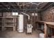 Basement utility area with hot water heater, furnace, exposed ductwork, and shelving at 136 W Maple Ave, Denver, CO 80223