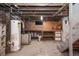 Basement utility area with hot water heater and exposed brick and ductwork at 136 W Maple Ave, Denver, CO 80223