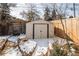 Metal shed for storage in winter with snow and brick lined path at 136 W Maple Ave, Denver, CO 80223