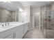 Bathroom featuring dual vanity sinks, walk-in shower, and marble floors at 6900 W Grant Ranch Blvd # 88, Denver, CO 80123