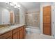Bathroom featuring granite vanity, tub with tile surround and glass door, and storage at 6900 W Grant Ranch Blvd # 88, Denver, CO 80123
