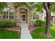 Charming home featuring a stone facade, arched entry, and well-maintained landscaping at 6900 W Grant Ranch Blvd # 88, Denver, CO 80123