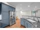 The kitchen features stainless steel appliances, blue cabinets, granite countertops, and hardwood floors at 6900 W Grant Ranch Blvd # 88, Denver, CO 80123