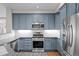 Modern kitchen with granite countertops, stainless steel appliances, and stylish blue cabinetry at 6900 W Grant Ranch Blvd # 88, Denver, CO 80123