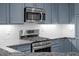 Well-equipped kitchen with stainless steel appliances and modern cabinetry with subway tile backsplash and granite countertops at 6900 W Grant Ranch Blvd # 88, Denver, CO 80123