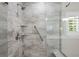 Walk-in shower features marble tile, showerhead, seat, grab bar, and glass door at 6900 W Grant Ranch Blvd # 88, Denver, CO 80123