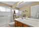 Bathroom featuring a mirror, vanity with wood cabinets, toilet, and glass-enclosed shower at 5317 W Iliff Dr # 101, Lakewood, CO 80227