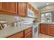 Well-lit kitchen featuring light countertops, wood cabinets, and modern appliances at 5317 W Iliff Dr # 101, Lakewood, CO 80227