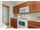 This is a kitchen with wooden cabinets, a white oven and microwave at 5317 W Iliff Dr # 101, Lakewood, CO 80227
