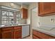 The kitchen features a stainless steel sink under a window, wooden cabinets, and a white dishwasher at 5317 W Iliff Dr # 101, Lakewood, CO 80227