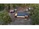 Aerial view of home nestled among trees, storage units, and large trucks in a rural area at 34480 County Road 17, Elizabeth, CO 80107