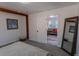 Bright bedroom featuring a full-length mirror, doorway view into living room, and exposed beam at 34480 County Road 17, Elizabeth, CO 80107