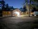 A beautifully lit brick home at night with modern fence, a stone patio, and an inviting outdoor space at 34480 County Road 17, Elizabeth, CO 80107