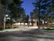 A cozy home at night, softly lit with a modern fence, set amongst mature trees and nestled on a spacious lot at 34480 County Road 17, Elizabeth, CO 80107