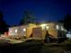 Exterior view of brick home featuring privacy fence, and mature trees at night at 34480 County Road 17, Elizabeth, CO 80107