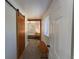 Hallway features a sliding wood door, light colored floors and a view into the bedroom at 34480 County Road 17, Elizabeth, CO 80107