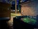 An inviting hot tub set against a brick exterior with modern fence and lush greenery, perfect for relaxing evenings at 34480 County Road 17, Elizabeth, CO 80107
