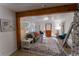 Inviting living room featuring rustic wood beam, stylish rug, and comfortable seating flooded with natural light at 34480 County Road 17, Elizabeth, CO 80107