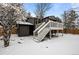 View of the home's back and side, with snowy yard and deck at 3530 W Edgemore Pl, Englewood, CO 80110