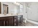 Bathroom featuring wood cabinets, dual sinks, and glass shower at 27862 E 9Th Dr, Aurora, CO 80018