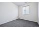 Empty bedroom featuring carpet, white walls, and a window at 27862 E 9Th Dr, Aurora, CO 80018