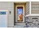 Inviting front entrance with a stylish glass door and stone accents, enhancing curb appeal at 27862 E 9Th Dr, Aurora, CO 80018