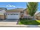 Inviting single-story home featuring a two-car garage, well-kept lawn, and attractive stone detailing at 27862 E 9Th Dr, Aurora, CO 80018