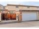 Exterior shot of garage with white door and brick facade, next to a fenced-in yard at 13015 W Ohio Ave, Lakewood, CO 80228