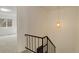 A bright stairwell featuring an interesting hanging light fixture and a black iron handrail at 13015 W Ohio Ave, Lakewood, CO 80228