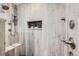 A stand up shower with light colored tiling, a built in bench and a shelf in the middle at 4776 Red Rock Dr, Larkspur, CO 80118