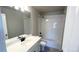 Bathroom with black fixtures, grey floor tiles, and white vanity at 2303 Peregrine Dr, Brighton, CO 80601