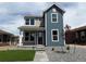 Charming two-story home with blue and grey siding and well-maintained front yard at 2303 Peregrine Dr, Brighton, CO 80601