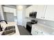 Bright kitchen with white cabinets, quartz countertops, and stainless steel microwave at 2303 Peregrine Dr, Brighton, CO 80601