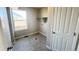 Laundry room with a window for natural light and gray tiled floors at 2303 Peregrine Dr, Brighton, CO 80601