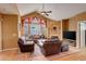 Comfortable living room with fireplace, ceiling fan, hardwood floors and large window at 2855 Rock Creek Cir # 129, Superior, CO 80027